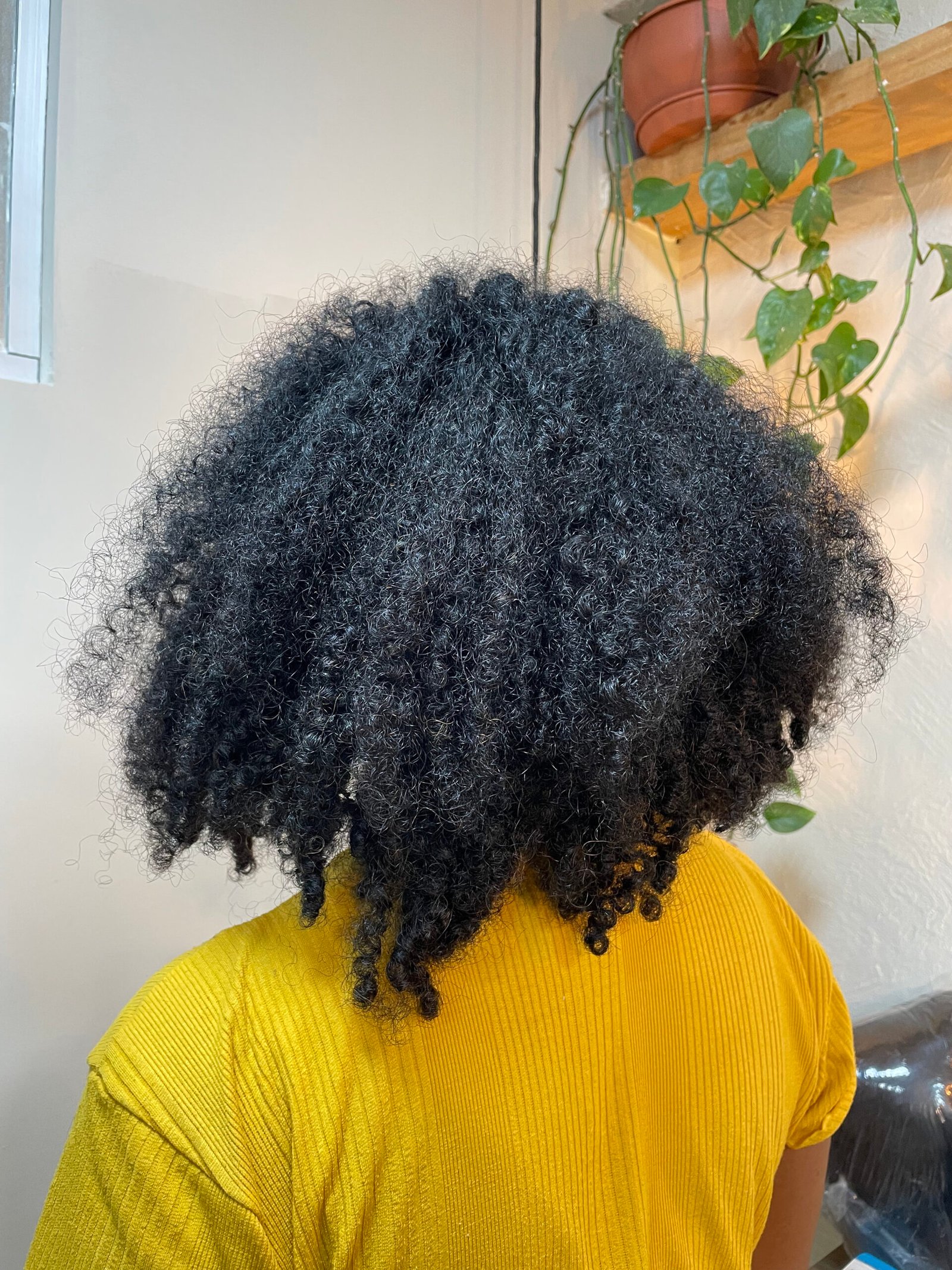 Antes do protocolo em cabelo cacheado da cliente de blusa laranja